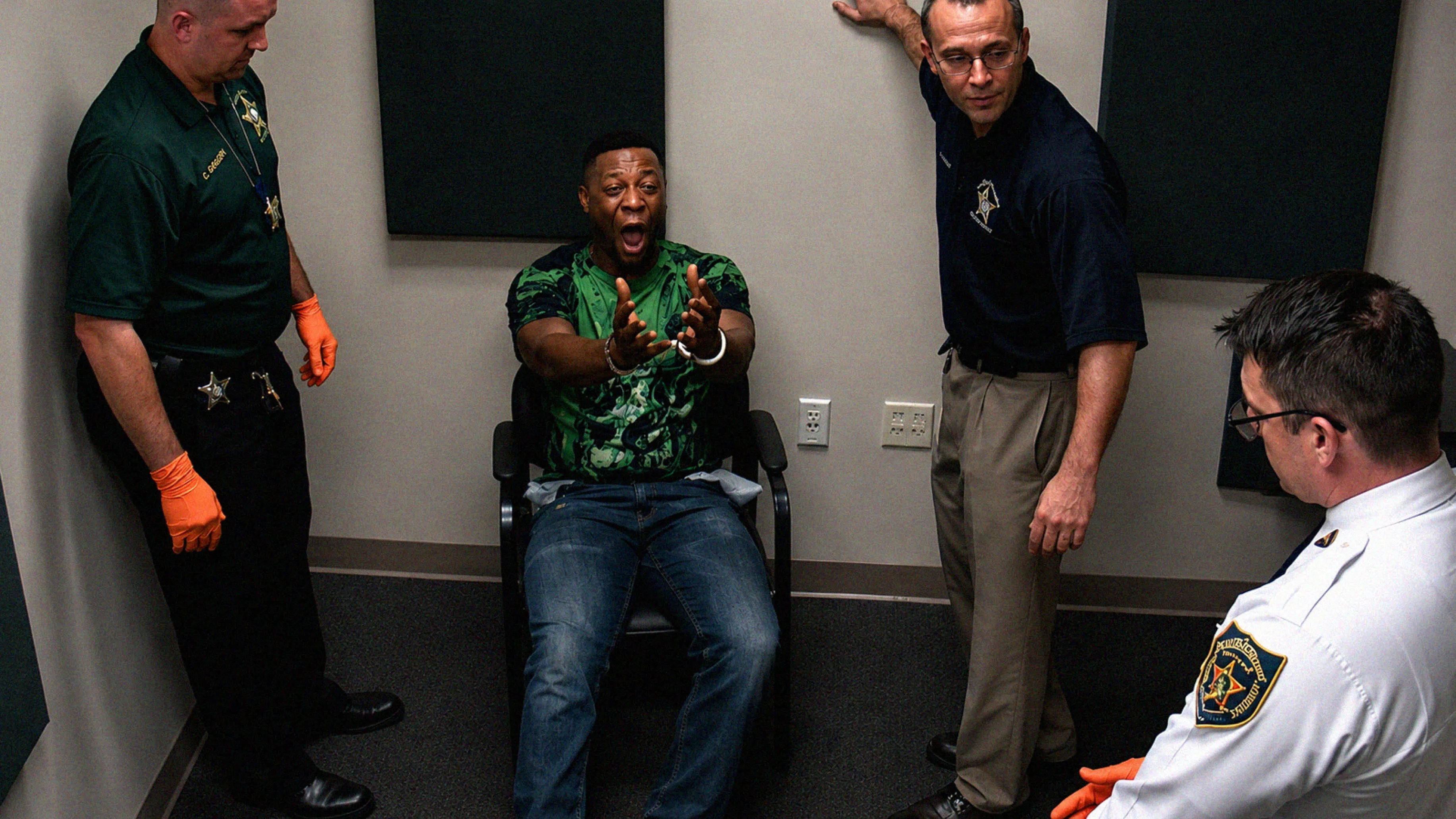 Investigadores observam Tyrone Johnson durante o interrogatório